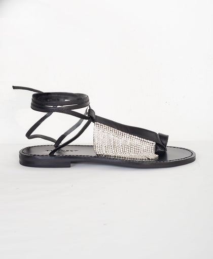 Vista laterale dei sandali neri infradito TwinSet in pelle con frange in strass sulla fascia centrale e allacciatura alla schiava alla caviglia