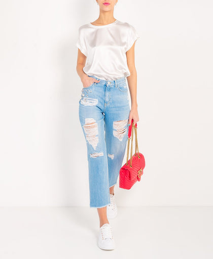 Outfit con il jeans Pinko in denim a vita alta con passanti con fondo sfrangiato e dettaglio di strass sulla gamba e rotture e graffiature
