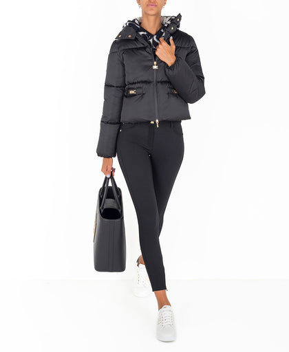 Outfit con il piumino corto nero Elisabetta Franchi a collo alto con dettaglio logo light gold e chiusura con zip a doppio tiretto e bottoni sul coll