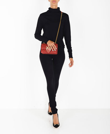 Outfit con la maglia nera Liviana Conti a collo alto e manica lunga con profili con lavorazione a costina e dettaglio a contrasto dietro