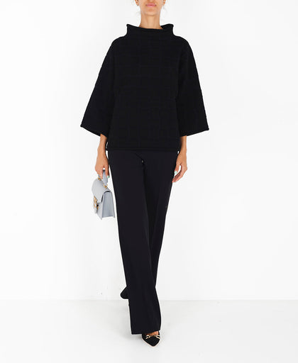 Outfit con la maglia nera Liviana Conti in lavorazione tridimensionale a quadri con collo a cratere e manica a tre quarti
